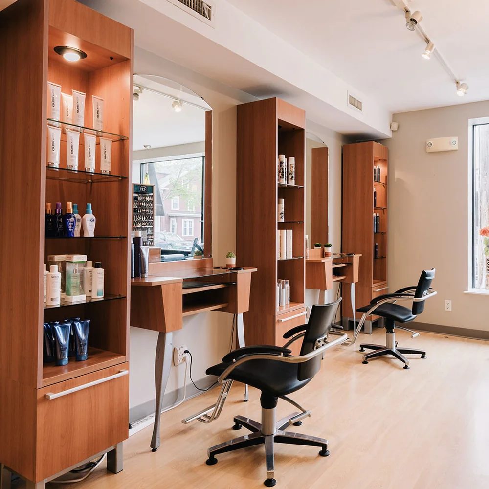 Styling stations with product shelves and mirrors at Jacqui's Design Group in Arlington, MA