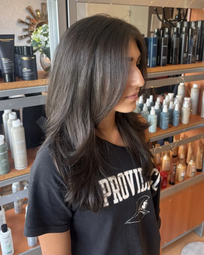 Long dark brown haircut with face-framing layers, styled at Jacqui's Design Group in Arlington, MA